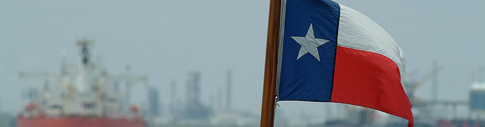Texas flag with a port as its backdrop.